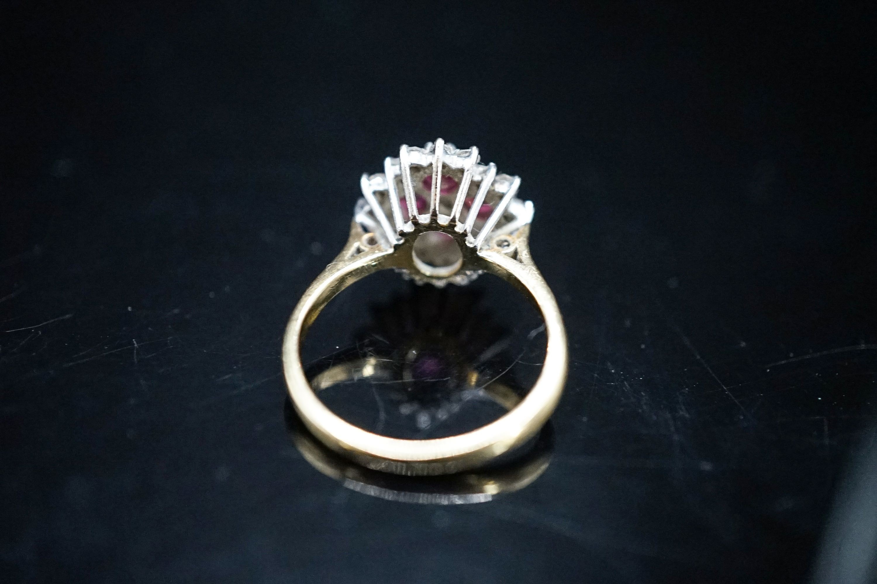 A modern 18ct gold, ruby and diamond cluster ring, size M, gross weight 4.2 grams.